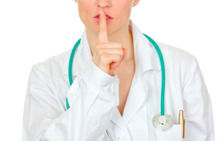 Medical doctor with finger at mouth isolated on white. Shh gesture
の写真素材