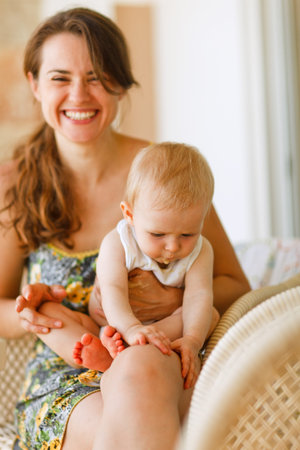 Laughing mother with baby sitting on kneesの写真素材