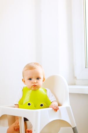Portrait of lovely eat smeared baby sitting in baby chair
の写真素材