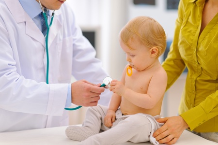 Baby being checked by pediatric doctor using stethoscopeの写真素材