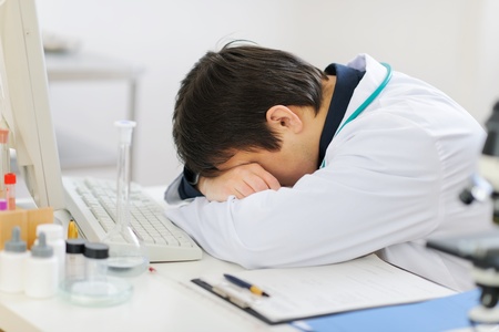 Tired medical doctor sleeping on keyboardの写真素材