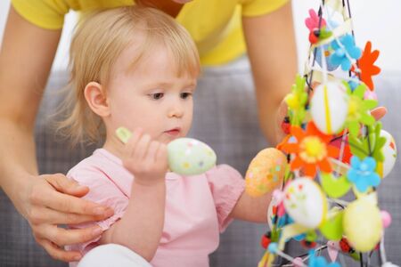 Mom helping baby made Easter decorationの写真素材
