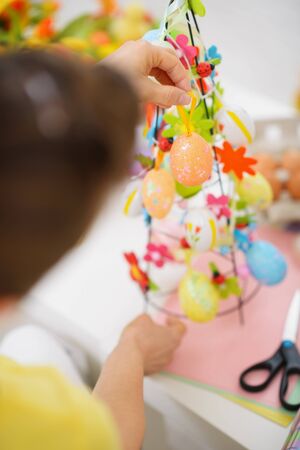 Closeup on female hands making Easter decorationの写真素材