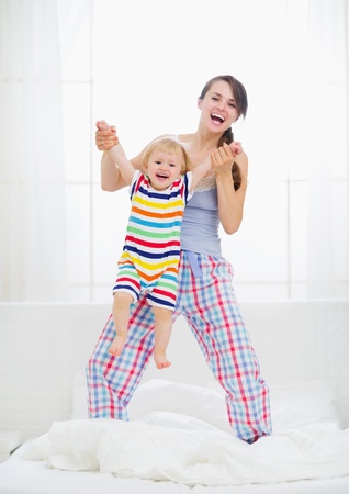 Mom playing with baby in bedroomの写真素材