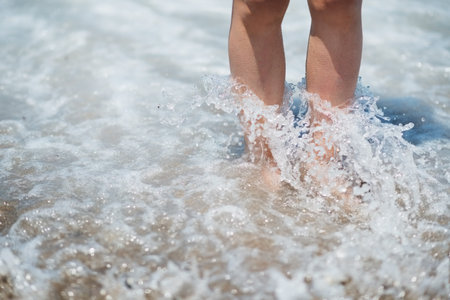 Closeup on legs in sea wave splashesの写真素材