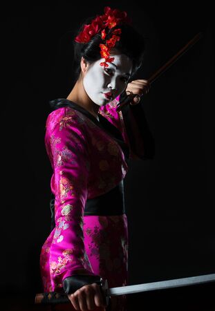 Portrait of geisha holding sword isolated on blackの写真素材