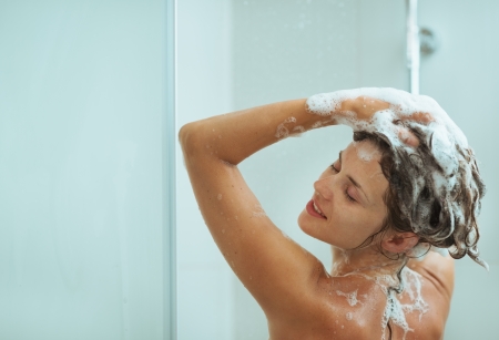 Woman applying shampoo in showerの写真素材