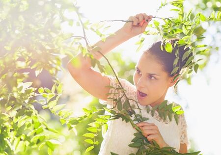 Surprised girl in foliage looking on copy spaceの写真素材
