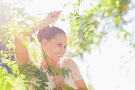 Portrait of young woman in foliage looking on copy spaceの写真素材