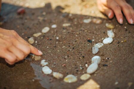 Closeup on rocks laid out in shape of heart on sandy beachの写真素材