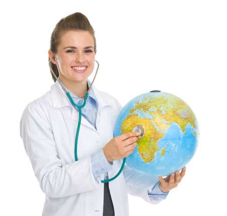 Happy medical doctor woman listening globe with stethoscopeの写真素材