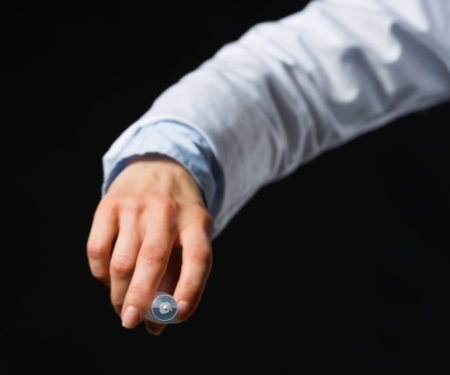 Closeup on hand with syringe isolated on blackの写真素材