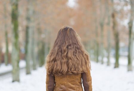 Young woman in winter park. rear viewの写真素材