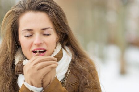 Young woman warming hands in winter outdoorsの写真素材