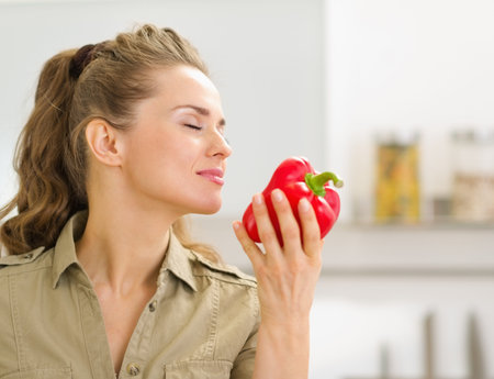 Young housewife enjoying fresh red bell pepperの写真素材