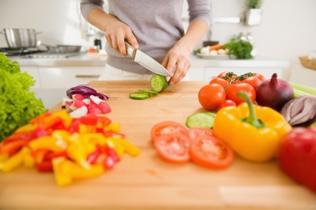 Closeup on young woman slicing vegetablesの写真素材