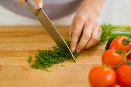 Closeup on housewife cutting fresh dillの写真素材