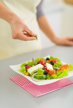 Closeup on woman adding fresh dill into saladの写真素材