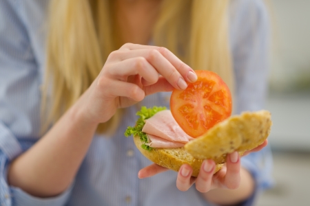 Closeup on young woman making sandwich in kitchenの写真素材