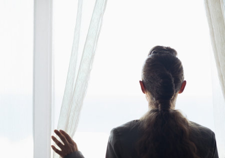 Silhouette of business woman looking into window