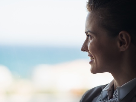 Silhouette of business woman looking into windowの写真素材