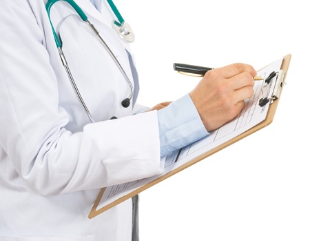 Closeup on doctor woman writing in clipboard