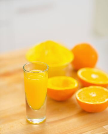 Closeup on glass of orange juice and oranges on cutting boardの写真素材