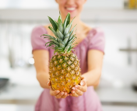 Closeup on pineapple in hand of housewifeの写真素材