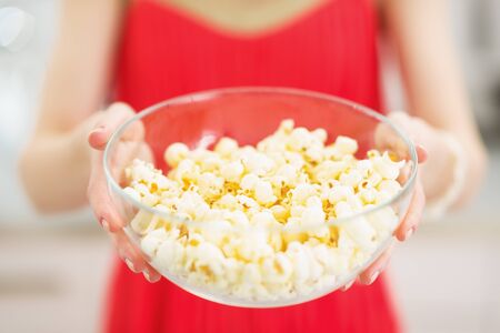 Closeup on plate with popcorn in hand of young womanの写真素材