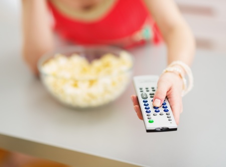 Closeup on tv remote control in hand of young womanの写真素材