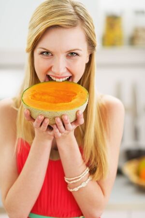 Portrait of happy young woman biting melonの写真素材