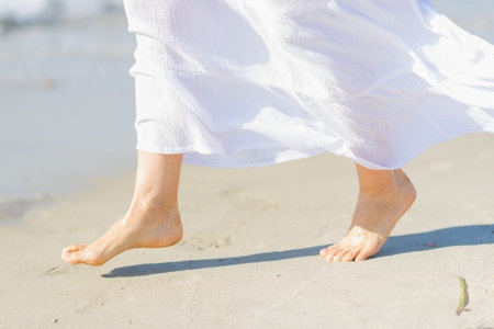 Closeup on leg of young woman on sea coastの写真素材