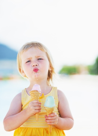 Happy baby enjoying two ice creamの写真素材