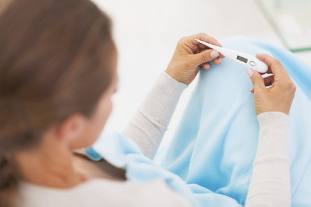 Young woman looking on thermometer