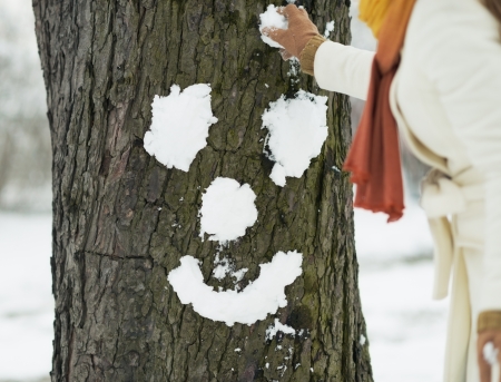 Young woman making face for tree using snowの写真素材