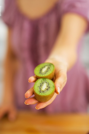 Closeup on kiwi slices in hand of young womanの写真素材