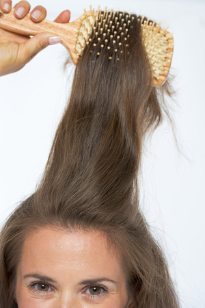 Closeup on young woman combing hairの写真素材