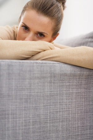 Stressed young woman sitting on couchの写真素材
