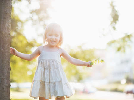 Portrait of happy baby girl in city parkの写真素材
