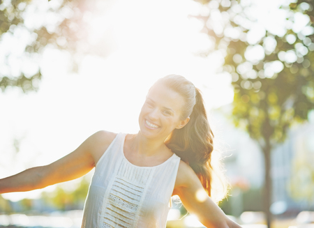 Smiling young woman having fun in city parkの写真素材