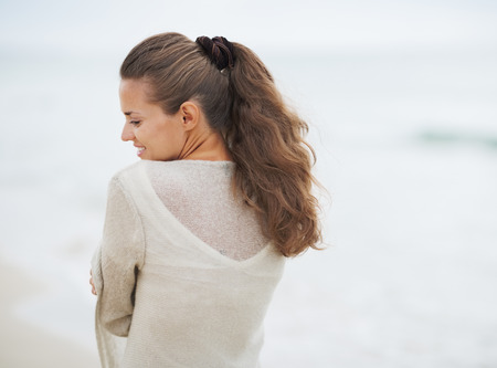 Portrait of young woman in sweater on lonely beachの写真素材