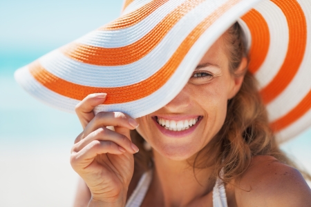 Portrait of happy young woman in swimsuit and beach hatの写真素材