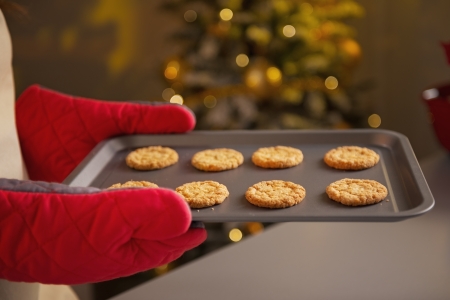Closeup on pan with christmas cookies in hand of young housewifeの写真素材
