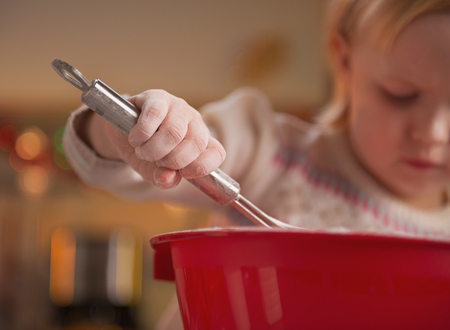 Closeup on baby kneading dough using whiskの写真素材
