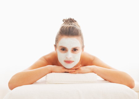 Young woman with revitalising mask on face laying on massage tableの写真素材
