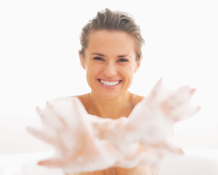 Smiling young woman showing hands in foamの写真素材