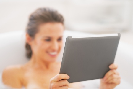 Closeup on young woman using tablet pc in bathtubの写真素材