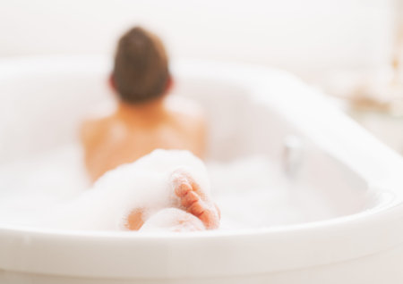 Closeup on legs of young woman in bathtub