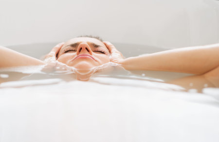 Stressed young woman laying in bathtub