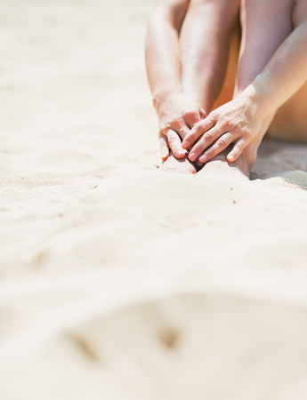 Closeup on young woman sitting on beachの写真素材